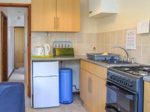 uma cozinha com um lavatório e um fogão em 25 Mallard Cottage- Uk38932 em Porthcurno