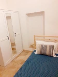- une chambre avec un lit et un miroir dans l'établissement Casa Borromeo, à Villa Castelli