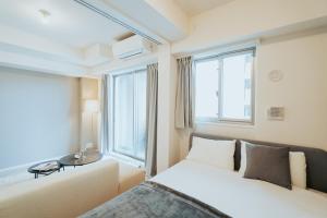- une chambre avec 2 lits et une fenêtre dans l'établissement n'estate Kagurazaka, à Tokyo