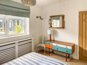 1 dormitorio con cama, tocador y espejo en Palm View en Paignton