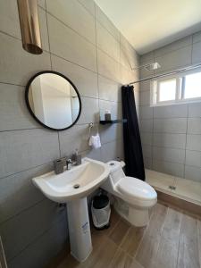 a bathroom with a sink and a toilet and a mirror at Habitación Cedros en Palmerola, Comayagua in Comayagua