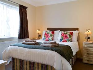 a bedroom with a bed with towels on it at Apple Blossom in Saint Ervan