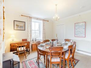 a dining room with a table and chairs at Colaboll Farmhouse in Lairg