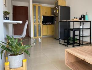 卡利的住宿－Gigi House，厨房配有黄色橱柜和黑色冰箱