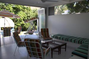 un patio con mesa, sillas y sombrilla en Finca Summerland ecohotel en Melgar
