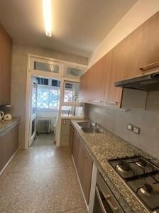 ラバトにあるAppartement moderne idéalement placé - haut agdalのシンクとコンロのあるキッチン トップオーブン +2枚の写真