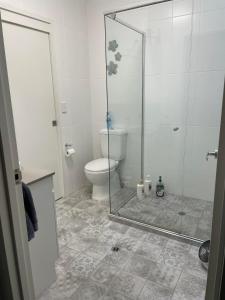 a bathroom with a toilet and a glass shower at Walk to Palmer B&B - U21 in Townsville