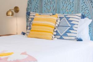 ein Bett mit blauen und weißen Kissen darauf in der Unterkunft Folly Fantasea in Folly Beach