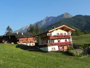 una casa con flores al lado de una colina en Matzenhof en Matrei in Osttirol
