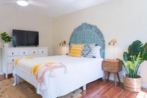 Schlafzimmer mit einem großen Bett mit blauem Kopfteil in der Unterkunft Folly Fantasea in Folly Beach