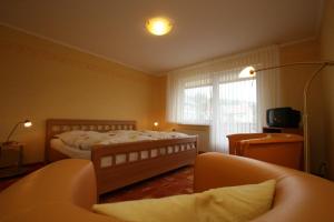 sypialnia z łóżkiem, kanapą i oknem w obiekcie Brauner Hirsch w mieście Hannoversch Münden