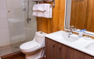 een badkamer met een toilet, een wastafel en een douche bij Hotel Gran Muso in Los Ángeles