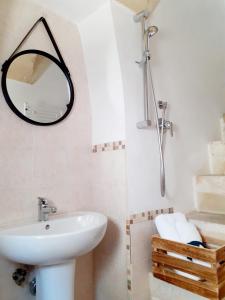 La salle de bains est pourvue d'un lavabo et d'un miroir. dans l'établissement Casa Borromeo, à Villa Castelli