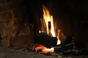 a fire is burning in a brick oven at Ski Rider Hotel in Kalkite