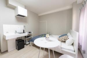 Un dormitorio pequeño con una cama y una mesa blanca. en 9stay蔵前, en Tokio