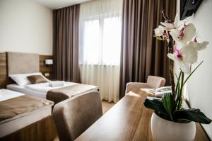 una habitación de hotel con una mesa con flores. en Villa Ruža, en Međugorje