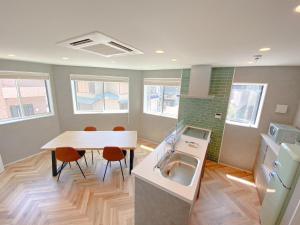 a kitchen with a sink and a table with chairs at machiyado kuwanajuku edomachi25 in Kuwana