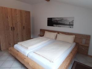 Bett in einem Zimmer mit Holzrahmen in der Unterkunft Schönbrunn holiday home in Bayrischzell in Bayrischzell
