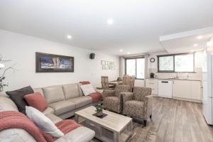 a living room with a couch and chairs and a kitchen at Lake Pines 2 of 24 Cobbon Crescent Free WiFi and Stay 7 nights only pay 6 in Jindabyne