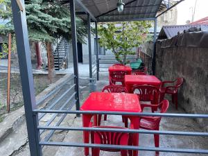 un groupe de tables et de chaises rouges sous un toit dans l'établissement Ankyun, à Gyumri