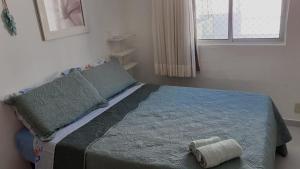 a bedroom with a bed with a pillow and a window at Vela e Mar in Nossa Senhora do Livramento