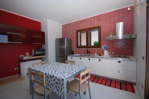 a kitchen with a table and a kitchen with red walls at Terrazza Sul Mare in Trapani +31 photos