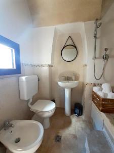 La salle de bains est pourvue de toilettes blanches et d'un lavabo. dans l'établissement Casa Borromeo, à Villa Castelli
