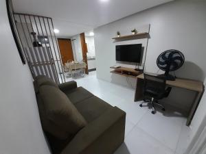 sala de estar con sofá y TV en Lindo Apartamento no Vuarnet, en João Pessoa