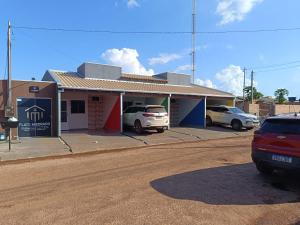 a building with cars parked in a parking lot at FlatsMedrado Hotel in Confresa
