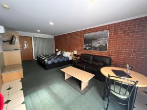 a living room with a couch and a table at Rose Garden Motel in Geelong