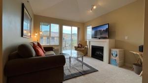 a living room with a couch and a fireplace at WATERSCAPES RESORT KELOWNA 2 FULL BEDROOMS SUITE VACATION RENTALS, SHORT TERM RENTALS. in Kelowna