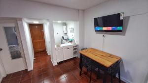 eine Küche mit einem Tisch und einem TV an der Wand in der Unterkunft Departamento en pleno centro Don Bosco 73 in Mendoza