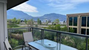 a balcony with a table and a view of the mountains at WATERSCAPES RESORT KELOWNA 2 FULL BEDROOMS SUITE VACATION RENTALS, SHORT TERM RENTALS. in Kelowna