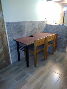 La Casita de Chocolate 2 في بوغوتا: طاولة خشبية ومقعد في الغرفة