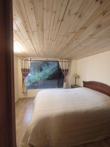 a bedroom with a large bed and a window at La Casita de Chocolate 2 in Bogotá