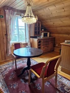 a dining room with a table and chairs in a cabin at Hotelli Luostarin Puutarha in Naantali