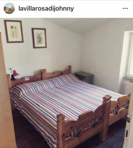 een slaapkamer met een bed met een gestreept dekbed bij La Villa Rosa di Johnny in Ronciglione