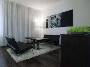 a living room with a table and chairs and a tv at arte Hotel Linz in Linz