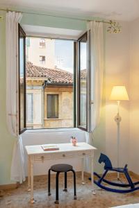 Cette chambre dispose d'un bureau et d'une chaise. dans l'établissement Billie's Flat WHITE - art & design apt in Verona historic centre, à Vérone