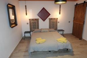 a bedroom with a bed with yellow towels on it at Aladin Comfort Country T3 in Campinho
