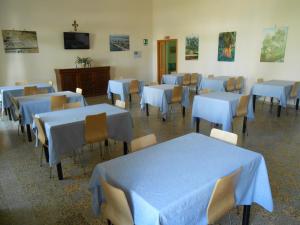 a room with blue tables and chairs and a tv at Sacro Cuore Opera Don Guanella in Torre Canne