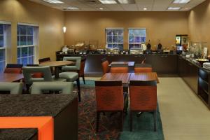 a restaurant with tables and chairs and a bar at Residence Inn Mystic Groton in Mystic