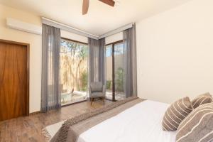 a bedroom with a bed and a large window at UTSKIN By ZENDA - Luxury Villas & Private Pools in Tulum +161 photos