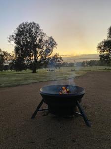 a grill with a fire in the middle of a field at Mansfield Glamping - ADULTS ONLY in Mansfield