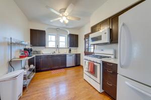 a kitchen with wooden cabinets and a white refrigerator at Pet-Friendly St Louis Home with Grill and Backyard in Richmond Heights