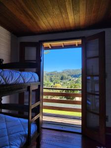 um quarto com beliches e uma porta de vidro deslizante em Chalés Monte Verde em Monte Verde