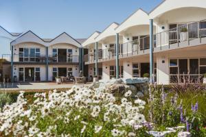 a row of buildings with flowers in the foreground at Radfords on the Lake in Te Anau