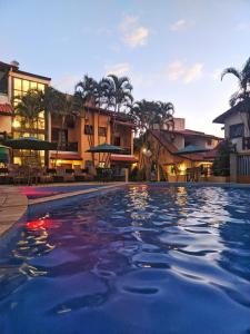 a large swimming pool in a resort with buildings at Villa'l Mare Hotel in Maresias