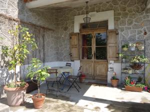 un patio con una mesa y algunas macetas en La Colline Bleue, en Banne