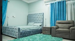 1 dormitorio con 1 cama y 1 silla en Cozy homes Accra,Ghana en Owuraman